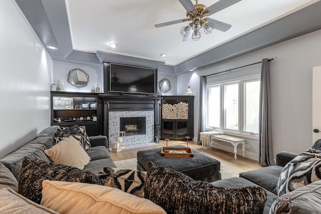 living area featuring a tiled fireplace, recessed lighting, ceiling fan, and wood finished floors