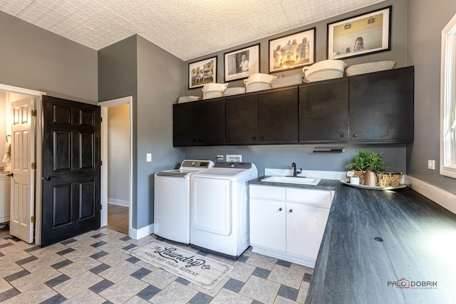 laundry area with washer and dryer, baseboards, cabinet space, and a sink