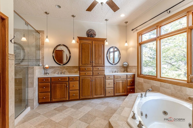 bathroom with a shower stall, a jetted tub, and double vanity