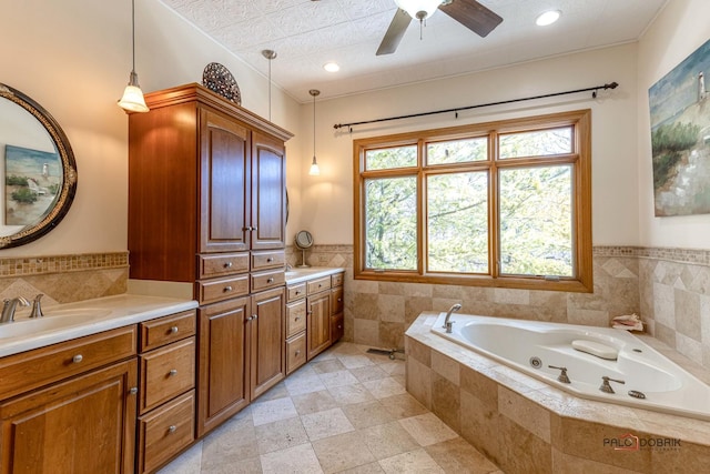 bathroom featuring recessed lighting, tile walls, a tub with jets, ceiling fan, and vanity