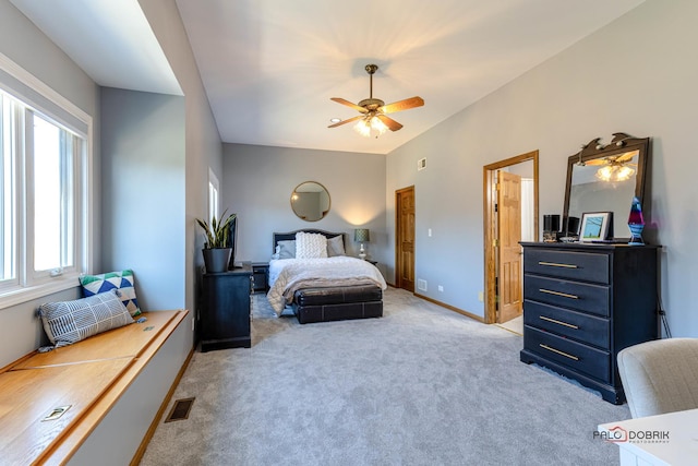 bedroom with a ceiling fan, light colored carpet, visible vents, and baseboards