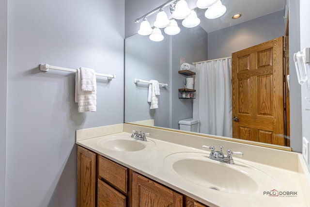 full bath with double vanity, toilet, a shower with shower curtain, and a sink