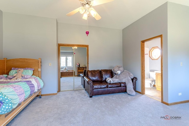 carpeted bedroom featuring baseboards, ensuite bathroom, and a ceiling fan