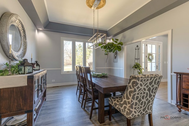 dining room featuring a notable chandelier, baseboards, and wood finished floors