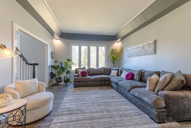 living room featuring stairs, crown molding, baseboards, and wood finished floors