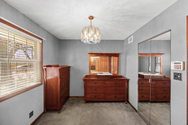 bedroom featuring visible vents, baseboards, a chandelier, light carpet, and a closet