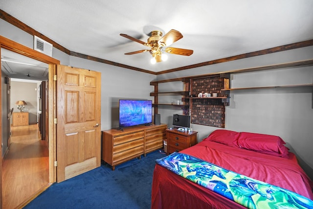 bedroom featuring visible vents, ornamental molding, a ceiling fan, dark colored carpet, and attic access