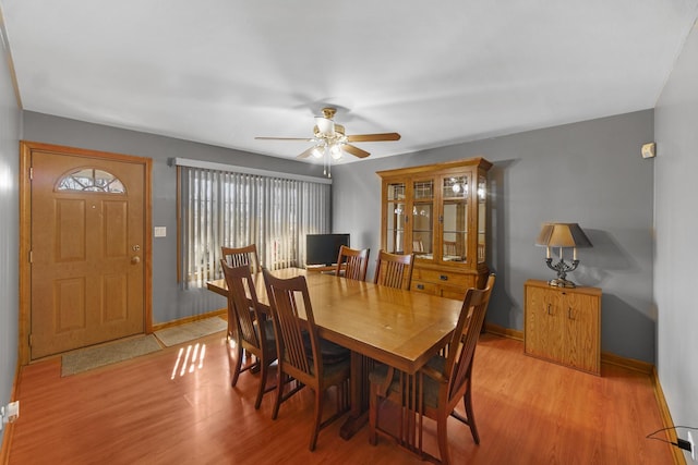 dining room with ceiling fan, light wood-type flooring, and baseboards