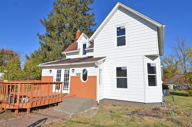 back of house featuring a wooden deck and french doors