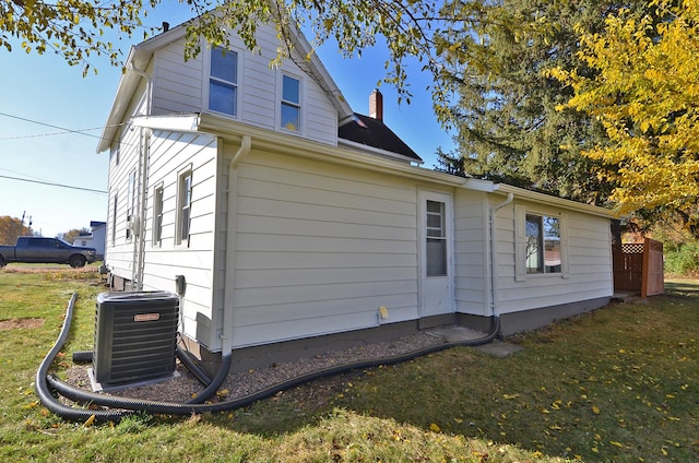 view of side of home featuring a yard and central air condition unit