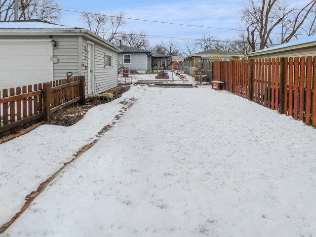 yard covered in snow featuring a garage