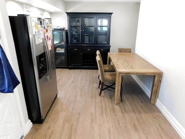 kitchen featuring stainless steel fridge with ice dispenser and light hardwood / wood-style flooring