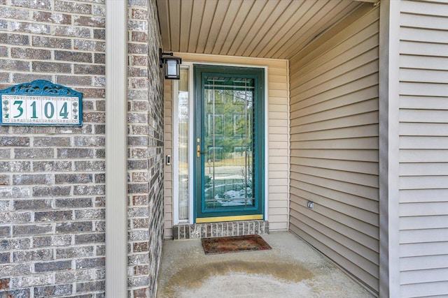 entrance to property featuring brick siding