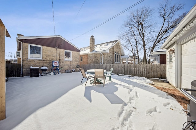 yard covered in snow featuring cooling unit and a garage