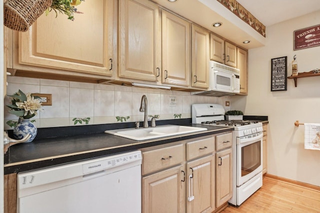 kitchen with light brown cabinetry, sink, tasteful backsplash, light wood-type flooring, and white appliances