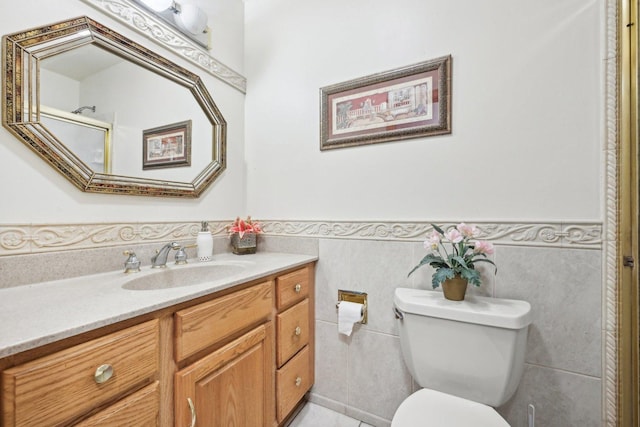 bathroom with vanity, tile walls, and toilet