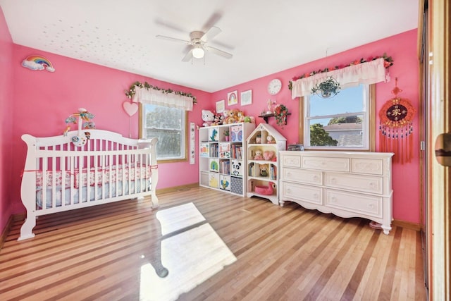 bedroom featuring multiple windows, hardwood / wood-style flooring, and ceiling fan