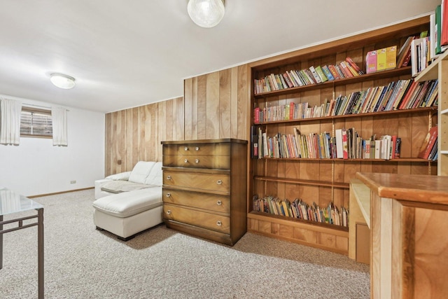 living area featuring light colored carpet and wood walls