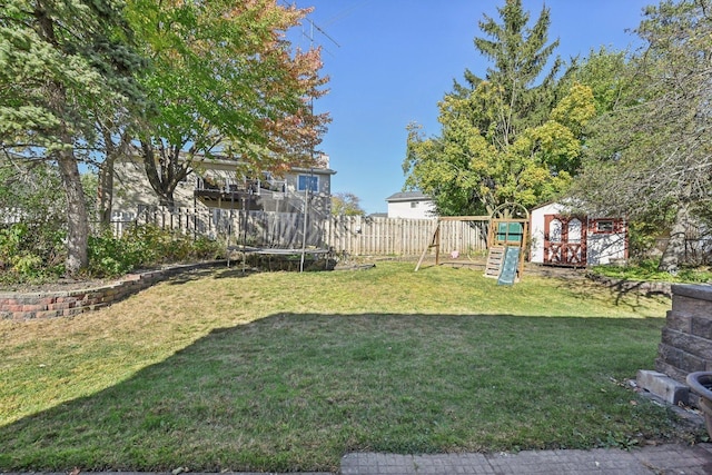 view of yard with a playground, a trampoline, and a shed