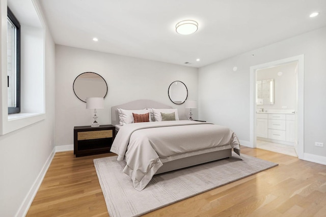 bedroom featuring light hardwood / wood-style floors and connected bathroom