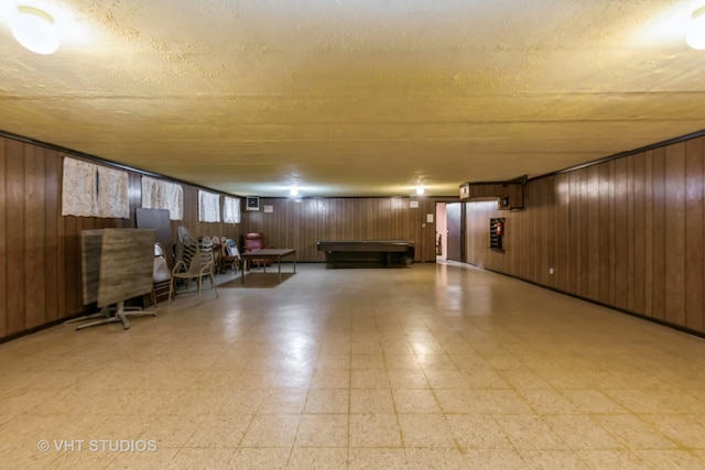 basement with a textured ceiling and wooden walls