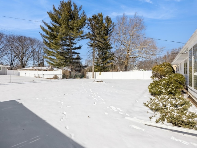 yard layered in snow featuring fence