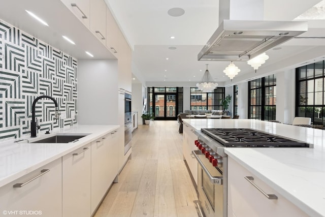 kitchen featuring light stone countertops, stainless steel appliances, a sink, and open floor plan