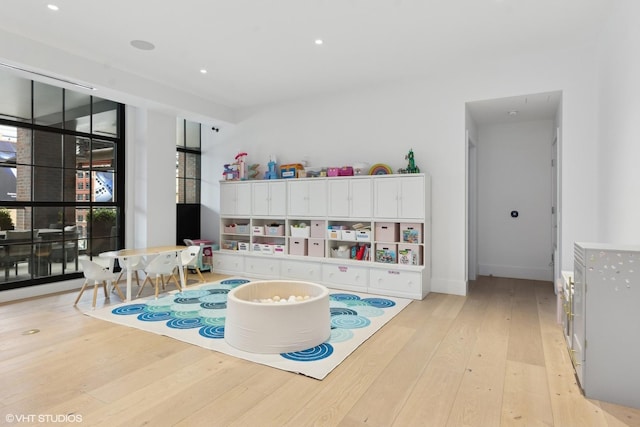 game room with a healthy amount of sunlight, light wood-style flooring, baseboards, and recessed lighting