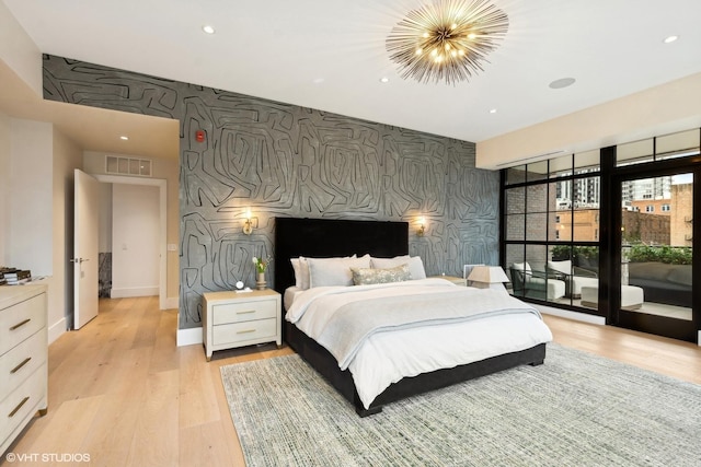 bedroom with wallpapered walls, light wood finished floors, visible vents, an accent wall, and access to exterior