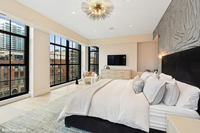 bedroom with an accent wall, recessed lighting, a notable chandelier, and light wood-style flooring