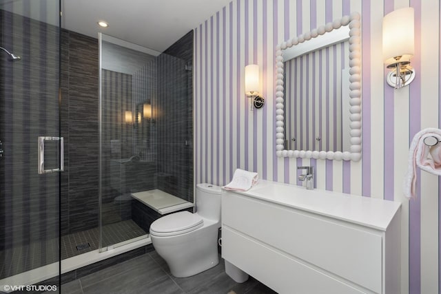 full bathroom featuring a stall shower, vanity, toilet, and wallpapered walls