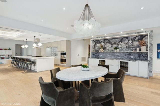 dining space featuring recessed lighting, beverage cooler, visible vents, light wood-type flooring, and an inviting chandelier