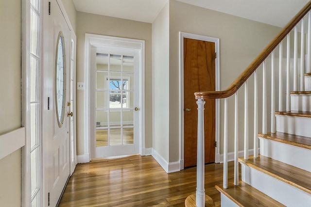 entryway with stairway, baseboards, and wood finished floors