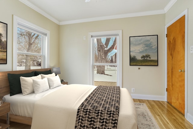 bedroom featuring ornamental molding, light wood-style flooring, and baseboards