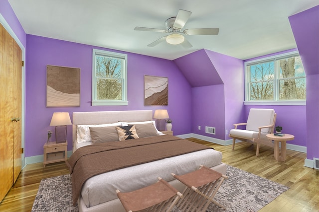 bedroom with multiple windows, baseboards, and wood finished floors