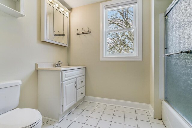 bathroom with a shower with door, toilet, vanity, tile patterned flooring, and baseboards