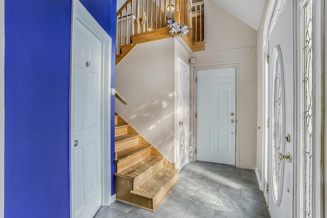 entryway with stairs and vaulted ceiling