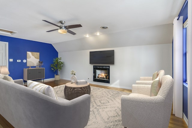 living room featuring lofted ceiling, wood finished floors, visible vents, and baseboards