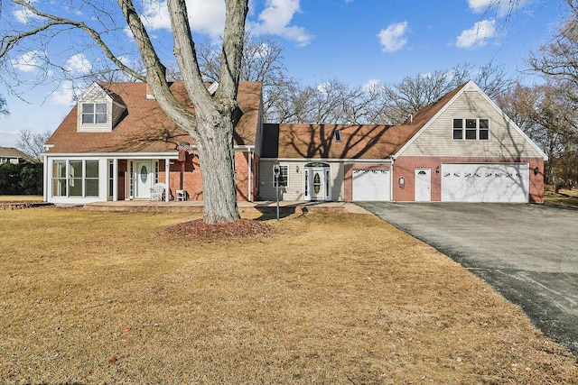 view of front of property with driveway, brick siding, and a front yard