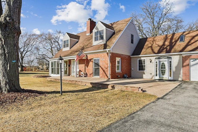 back of house with brick siding and a chimney