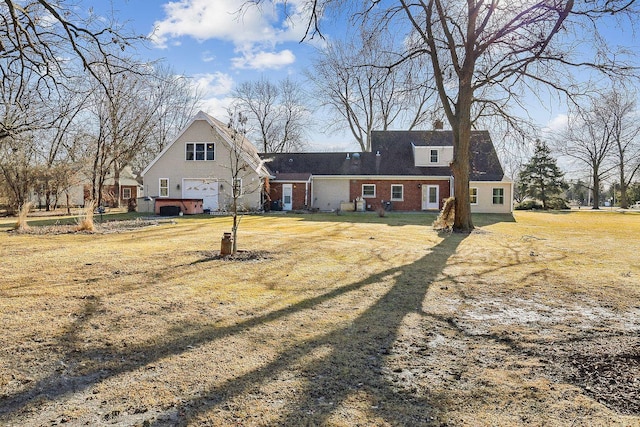 view of front of house featuring a garage, brick siding, and a front yard