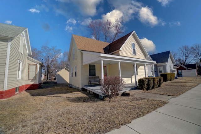 view of home's exterior featuring covered porch and a shingled roof