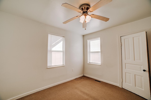 unfurnished room featuring light colored carpet, visible vents, ceiling fan, and baseboards