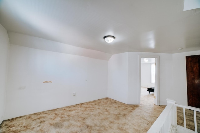 carpeted empty room with lofted ceiling