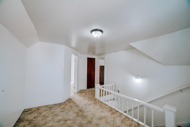 additional living space featuring carpet floors and vaulted ceiling