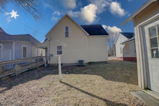 view of property exterior with cooling unit, fence, and a lawn