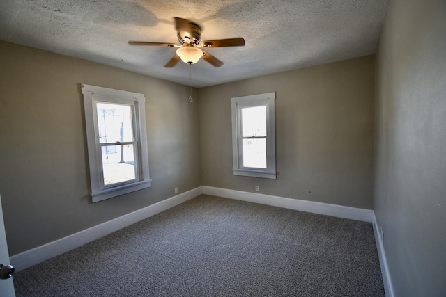 carpeted empty room featuring ceiling fan, a textured ceiling, and baseboards