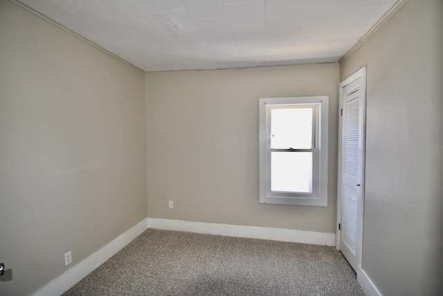 carpeted empty room with baseboards