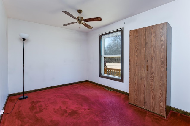 spare room with carpet floors, visible vents, baseboards, and a ceiling fan