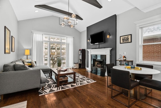 living area featuring dark wood-style floors, a fireplace, plenty of natural light, and a chandelier